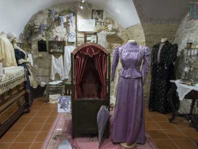 Ecco poi spiccare un elegante vestito lungo da donna color viola. Presenta una vita sottilissima, delle maniche gonfie "a prosciutto" e una gonna a forma di campana che si allunga lambendo il pavimento